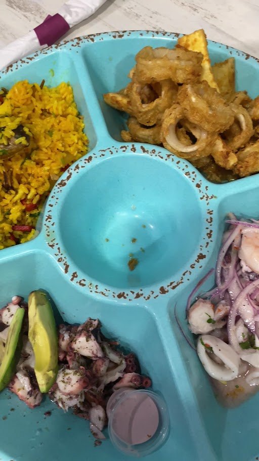 Plates of ceviche and fried seafood on display.
